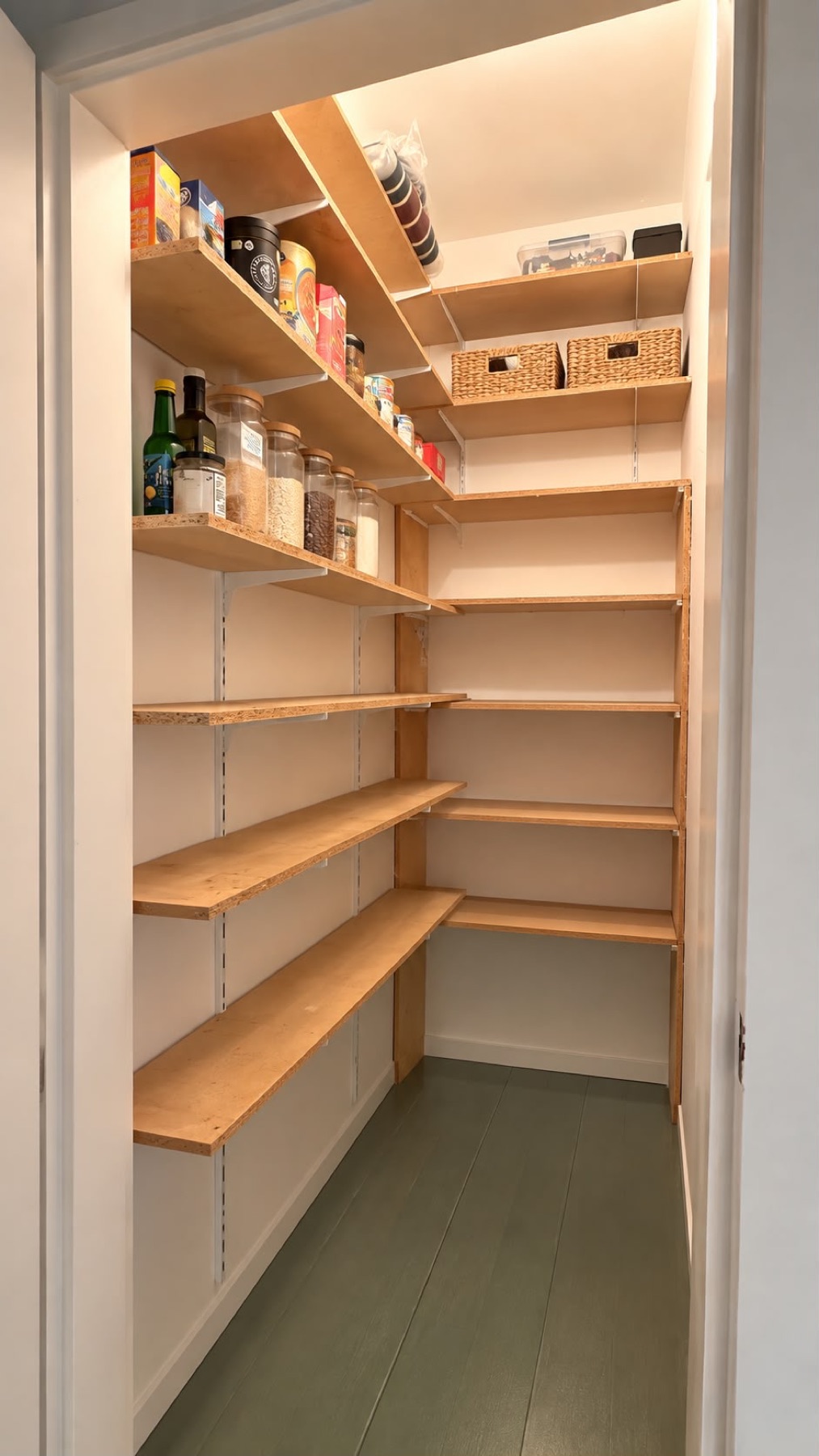 Walk-in pantry with wooden shelves on two walls